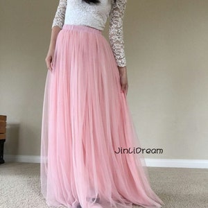 K&ouml;nnte beinhalten: Ein langer, rosa T&uuml;llrock mit einem wei&szlig;en Spitzenoberteil. Der Rock ist flie&szlig;end und hat einen weichen, zarten Look. Der Text "JinLiDream" ist auf dem Rock sichtbar.