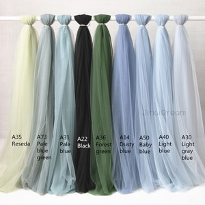 May include: Nine different colors of tulle fabric swatches, including pale blue, light gray, forest green, black, dusty blue, baby blue, light blue, pale green, and pale yellow.