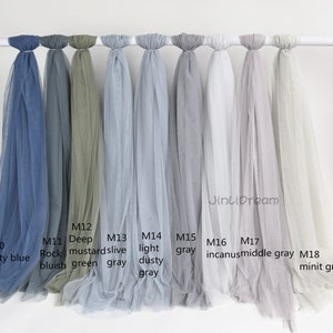 May include: Eight different colors of sheer fabric swatches, labeled with their color names and product codes. The colors are dusty blue, rock bluish, deep mustard green, olive gray, light dusty gray, gray, incanus, middle gray, and minit gray.