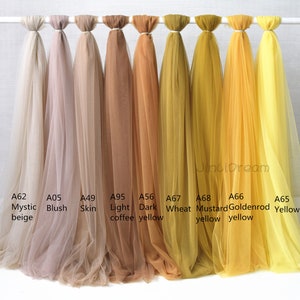 May include: Nine swatches of sheer fabric in various shades of beige, brown, and yellow. The swatches are labeled with color names and codes, including Mystic beige, Blush, Skin, Light coffee, Dark yellow, Wheat, Mustard yellow, Goldenrod yellow, and Yellow.