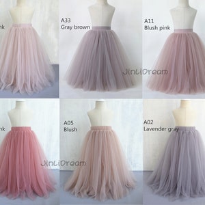 K&ouml;nnte beinhalten: Sechs T&uuml;llr&ouml;cke in verschiedenen Farben, darunter Blush Pink, Grau Braun, Ros&eacute;gold, Lavendel Grau und Blush. Die R&ouml;cke werden auf Mannequins pr&auml;sentiert und haben einen einfachen elastischen Bund. Der Text "JinLiDream" ist auf zwei der R&ouml;cke sichtbar.