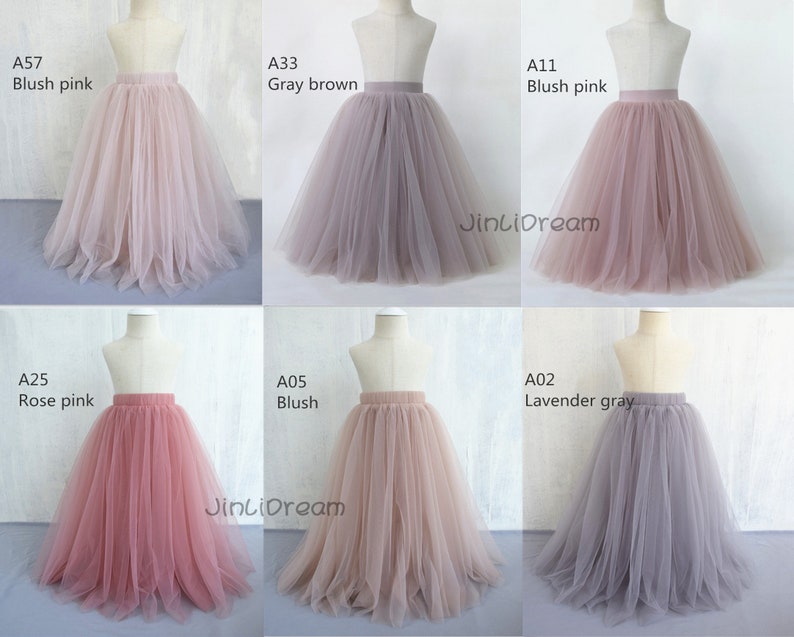 K&ouml;nnte beinhalten: Sechs T&uuml;llr&ouml;cke in verschiedenen Farben, darunter Blush Pink, Grau Braun, Ros&eacute;gold, Lavendel Grau und Blush. Die R&ouml;cke werden auf Mannequins pr&auml;sentiert und haben einen einfachen elastischen Bund. Der Text "JinLiDream" ist auf zwei der R&ouml;cke sichtbar.
