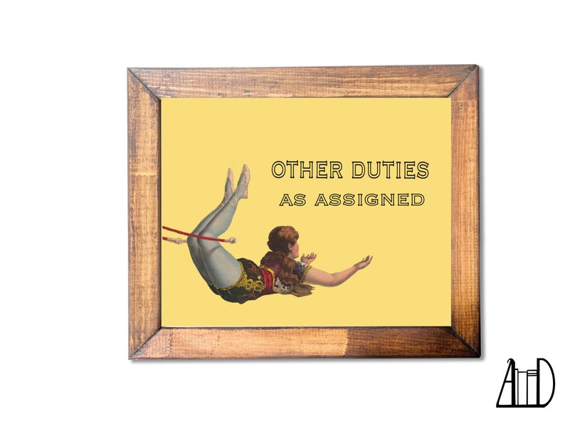 May include: Wooden framed print with a yellow background featuring a vintage illustration of a person in a circus act. The text "OTHER DUTIES AS ASSIGNED" is displayed in black letters. The frame is made of brown wood.