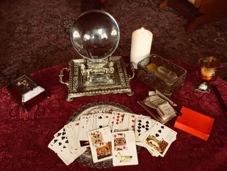 May include: A fortune teller's table with a crystal ball, tarot cards, a candle, and a small box.