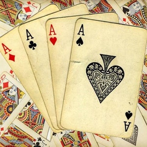May include: Four playing cards fanned out, showing the ace of spades, the ace of hearts, the ace of clubs, and the ace of diamonds. The cards are all in a vintage style with a worn, yellowed look.