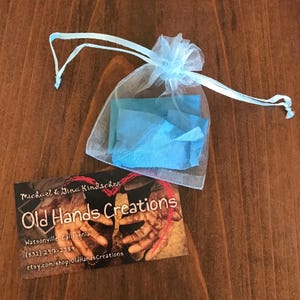 May include: A light blue organza bag with a white drawstring. The bag is filled with blue tissue paper. A business card is on a wooden surface. The business card reads "Michael & Dina Kindschen Old Hands Creations Watsonville, California (831) 247-2389 etsy.com/shop/OldHandsCreations"