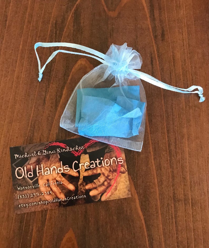 May include: A light blue organza bag with a white drawstring. The bag is filled with blue tissue paper. A business card is on a wooden surface. The business card reads "Michael & Dina Kindschen Old Hands Creations Watsonville, California (831) 247-2389 etsy.com/shop/OldHandsCreations"