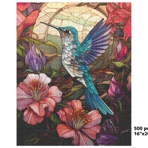 May include: A 500-piece jigsaw puzzle featuring a vibrant illustration of a hummingbird with turquoise and blue feathers, surrounded by pink and red flowers. The puzzle measures 16 inches by 20 inches.