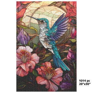 May include: A colorful jigsaw puzzle featuring a hummingbird with blue, teal, and white feathers, surrounded by pink and red flowers and purple buds. The puzzle is 20" x 30" and contains 1014 pieces.