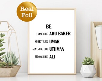 May include: A white framed print with black text that reads "BE LOYAL LIKE ABU BAKER HONEST LIKE UMAR GENEROUS LIKE UTHMAN STRONG LIKE ALI". The print is on a white shelf with a gold geometric terrarium with succulents and a wooden file holder with books on the right.