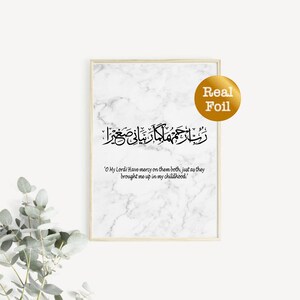 May include: A printable wall art design featuring an Islamic prayer in Arabic script with a translation in English. The design is on a white marble background with a gold foil accent. The text reads: 'O My Lord! Have mercy on them both, just as they brought me up in my childhood.'