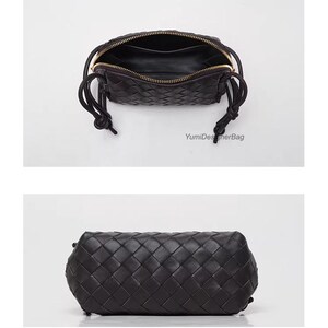 K&ouml;nnte beinhalten: Schwarze Handtasche aus geflochtenem Leder mit Rei&szlig;verschluss und goldfarbenen Details. Die Tasche hat eine rechteckige Form mit geknoteten Kordelz&uuml;gen. Das Innere ist sichtbar, und der Markenname "YumiDesignerBag" ist aufgedruckt.