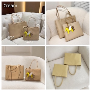 May include: Two cream-colored tote bags in large and small sizes, each featuring two thin handles. The smaller bag includes a yellow winged horse charm with a brown tail. The text "Cream", "Large", and "Small" is visible in the image.