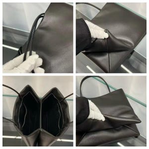 May include: A dark brown leather tote bag featuring thin shoulder straps, a smooth exterior finish, and a structured base. The interior is divided into two main compartments with open side pockets, showcasing a clean, functional design.