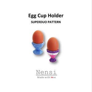 Op de afbeelding: Twee geperde eierdopjes, een blauwe en een met paarse, roze en witte strepen. De eierdopjes houden bruine eieren vast. De tekst "SUPERDUO PATTERN" staat boven de eierdopjes. De tekst "Nensi Made with love" staat onder de eierdopjes.