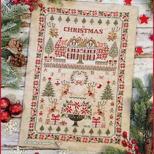 Könnte beinhalten: Ein Kreuzstich-Weihnachtsmuster mit einem Haus, Rentieren, Weihnachtsbäumen und dem Wort "CHRISTMAS". Das Design verwendet Rot-, Grün- und Beigetöne mit einem dekorativen Rand.