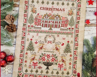 May include: A cross-stitch Christmas sampler featuring a house, reindeer, Christmas trees, and the word "CHRISTMAS". The design includes red, green, and beige colors, with a decorative border and festive elements.