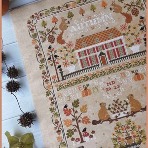 Peut inclure: Mod&egrave;le de point de croix repr&eacute;sentant une charmante sc&egrave;ne d'automne avec une maison, des arbres, des animaux et le mot "Automne". Le mod&egrave;le est con&ccedil;u par "Crocette a gogo".