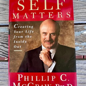 May include: A hardcover book titled "SELF MATTERS" by Phillip C. McGraw, Ph.D. The cover is red with the title in large, gold letters. The book features a photo of the author in a suit. The subtitle reads "Creating Your Life from the Inside Out."