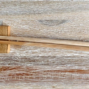 K&ouml;nnte beinhalten: Ein Paar Holzst&auml;bchen mit den Worten "Martin" und "Guten Appetit" eingraviert. Die St&auml;bchen liegen auf einem Holzst&auml;bchenhalter.