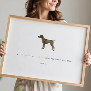 May include: A framed print with a brown dog illustration and the text "WHERE YOU GO I WILL GO AND WHERE YOU STAY I WILL STAY. RUTH 1:16". The artwork is set in a light wooden frame. The text is in a simple, elegant font.