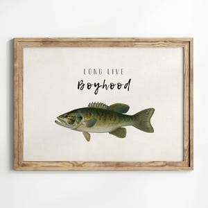 May include: A framed print with a brown wooden frame. The print features a green and brown fish illustration with the text "Long Live Boyhood" in black.