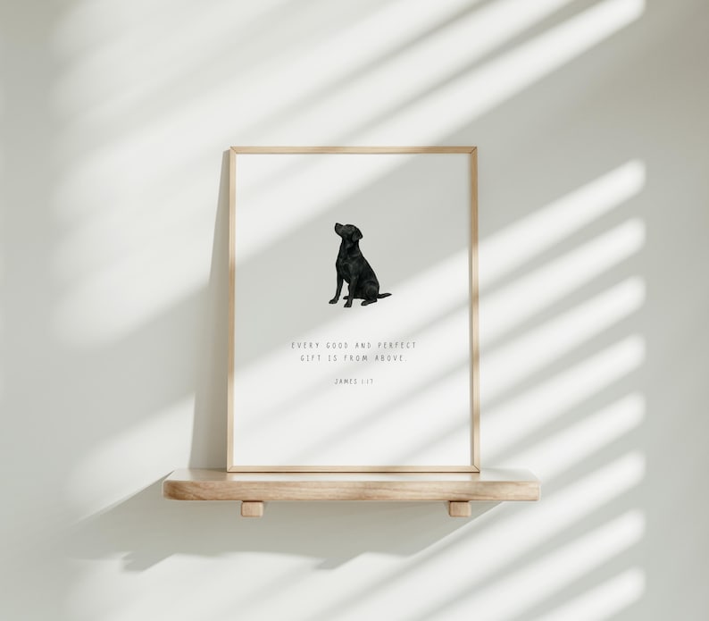 Może przedstawiać: Oprawiony wydruk z czarną sylwetką labradora na białym tle. Wydruk zawiera tekst &bdquo;EVERY GOOD AND PERFECT GIFT IS FROM ABOVE&rdquo; i &bdquo;JAMES 1:17&rdquo;. Grafika jest prezentowana na drewnianej p&oacute;łce.