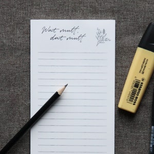 Może przedstawiać: Biały notes z czarnym ołówkiem, czarnym długopisem i żółtym markerem. Na notesie widnieje napis "What must, that must".