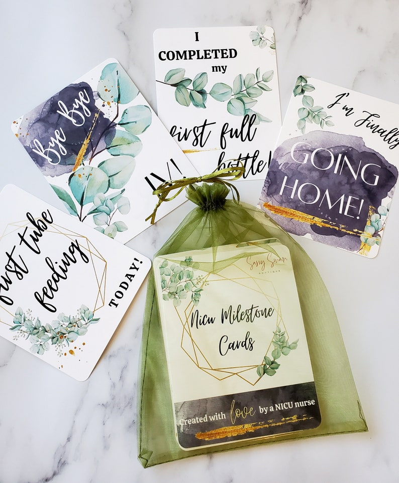 K&ouml;nnte beinhalten: Ein Satz von f&uuml;nf Karten mit Aquarellhintergr&uuml;nden und goldenen Akzenten. Die Karten zeigen Meilensteine f&uuml;r ein Baby auf der Neugeborenenintensivstation, wie z. B. &bdquo;Ich habe meine erste volle Flasche geschafft&ldquo; und &bdquo;Ich gehe endlich nach Hause!&ldquo;. Die Karten sind in einem gr&uuml;nen Organzas&auml;ckchen verpackt mit dem Text &bdquo;NICU Milestone Cards&ldquo; und &bdquo;Created with love by a NICU nurse&ldquo;.