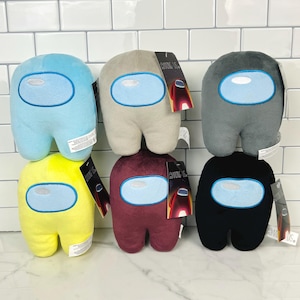 May include: Six plush toys shaped like characters from the video game Among Us. The toys are in different colours: light blue, grey, yellow, maroon, black, and beige. Each toy has a large, round, blue visor.