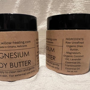 May include: Two brown jars of magnesium body butter with black lids. The label on the left jar reads "www.willow-healing.com Made in Omaha, Nebraska MAGNESIUM BODY BUTTER TO USE: apply to clean skin and gently massage into skin. For external use only."