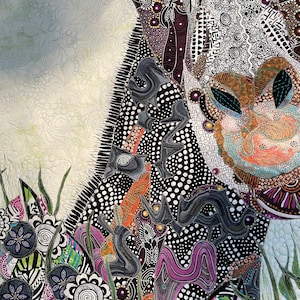 May include: A close-up of a colorful, abstract quilt with a black, white, and purple design. The quilt is made of various fabrics and textures, and features a variety of geometric shapes and patterns.