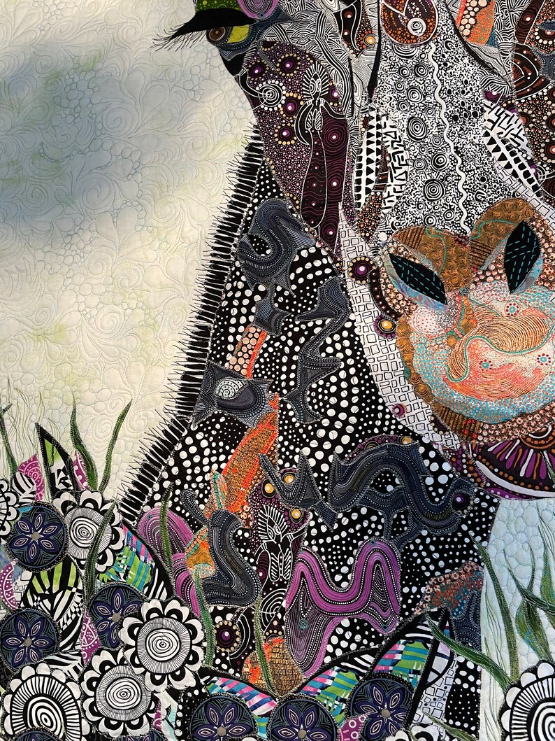 May include: A close-up of a colorful, abstract quilt with a black, white, and purple design. The quilt is made of various fabrics and textures, and features a variety of geometric shapes and patterns.