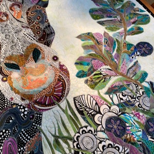 May include: A colorful quilt with a white background featuring a large, abstract floral design. The quilt is made of various fabrics and textures, including black and white polka dots, green leaves, and purple flowers.