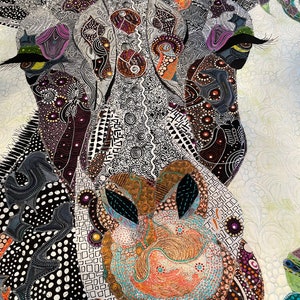 May include: Close-up of a colorful, patterned quilt depicting a giraffe's face. The quilt is made of various fabrics and textures, creating a unique and intricate design. The giraffe's eye is large and prominent, with a black and white pattern.