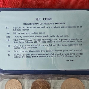 May include: A close-up of a display showing the reverse designs of Fiji coins. The display includes a description of each coin, including its denomination, name, and a brief description of the design. The coins are arranged in a row, with the largest coin on the left and the smallest coin on the right.