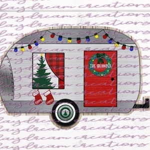 Puede incluir: Una caravana gris y blanca con una puerta roja y un &aacute;rbol de Navidad en la ventana. La caravana tiene luces de cadena y una corona en la puerta. El texto "THE GILMORES" est&aacute; en la corona. El texto "HAPPY CAMPERS" est&aacute; en la parte inferior de la caravana.
