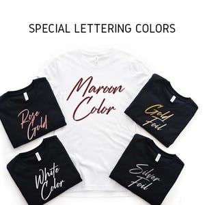 以下が含まれることがあります： Maroon Colorと書かれた白いTシャツと、Rose Gold、Gold Foil、White Color、Silver Foilと書かれた4枚の黒いTシャツ。画像の上部には、利用可能なオプションを表示するSPECIAL LETTERING COLORSという見出しが含まれています。