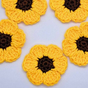 May include: Five crocheted sunflower appliques with brown centres and yellow petals.