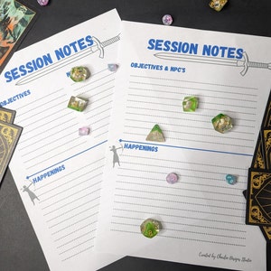 May include: Two white sheets of paper with blue lines and the text "SESSION NOTES" printed in blue at the top. The sheets are labeled "OBJECTIVES" and "HAPPENINGS". There are several small, colorful dice scattered on the sheets.