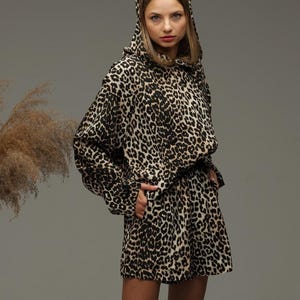 May include: A hooded top and matching shorts in a leopard print pattern. The top has long sleeves and a relaxed fit. The shorts have a drawstring waist.