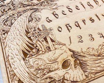 Ouija board with demons and skulls engraved on wood , wooden spirit board in gothic style with  demons planchette