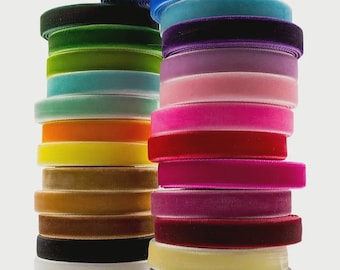 May include: Stacks of colorful velvet ribbon in various shades, including blue, green, orange, yellow, pink, and burgundy. The ribbon is neatly rolled and stacked, showcasing the texture and color variations. Ideal for crafting and decorative projects.