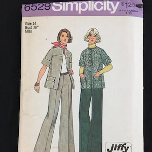 May include: Simplicity sewing pattern number 6529 for a Jiffy easy cut-easy sew top and pants. The pattern is for size 14, bust 36 inches. The pattern shows two women wearing the top and pants in different colors.