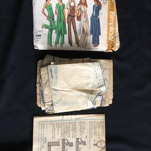 May include: A vintage Simplicity sewing pattern packet featuring illustrations of women's clothing designs. The packet includes pattern pieces and instructions. The design is for knit fabrics. The packet is labelled "$263 Simplicity".