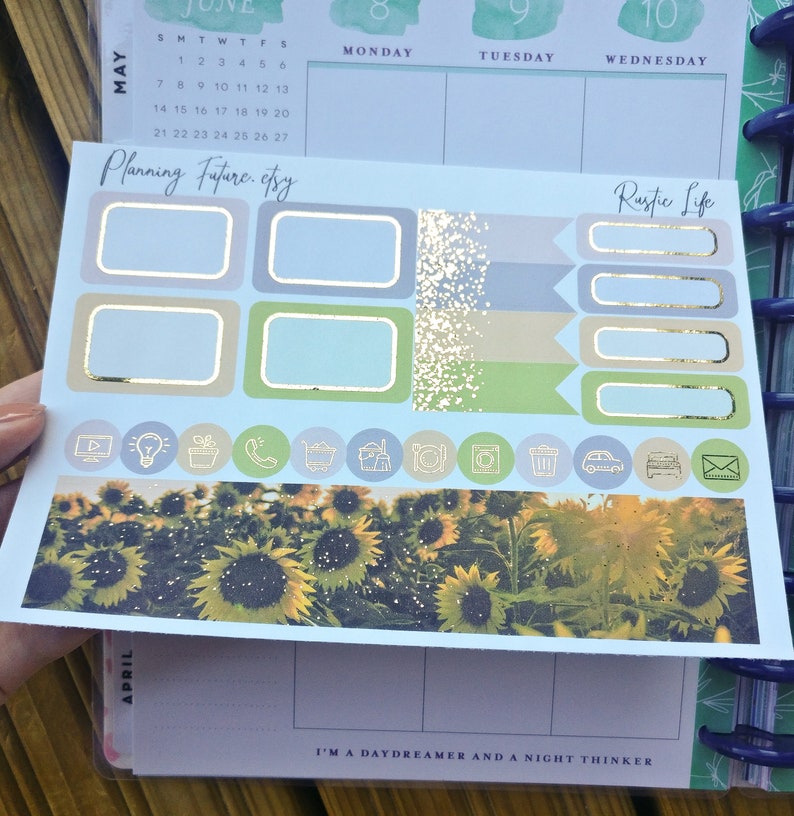 Puede incluir: Un conjunto de pegatinas para planificador con tem&aacute;tica de girasol. Las pegatinas est&aacute;n sobre un fondo azul claro con detalles dorados. Las pegatinas incluyen una variedad de dise&ntilde;os, incluyendo girasoles, un calendario y el texto "Planning Future.etsy" y "Rustic Life".