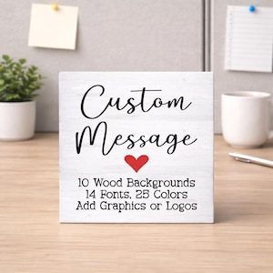 May include: A white wooden sign with the words "Custom Message" in black script, a red heart, and text detailing options for backgrounds, fonts, and colors. The sign is on a wooden surface.
