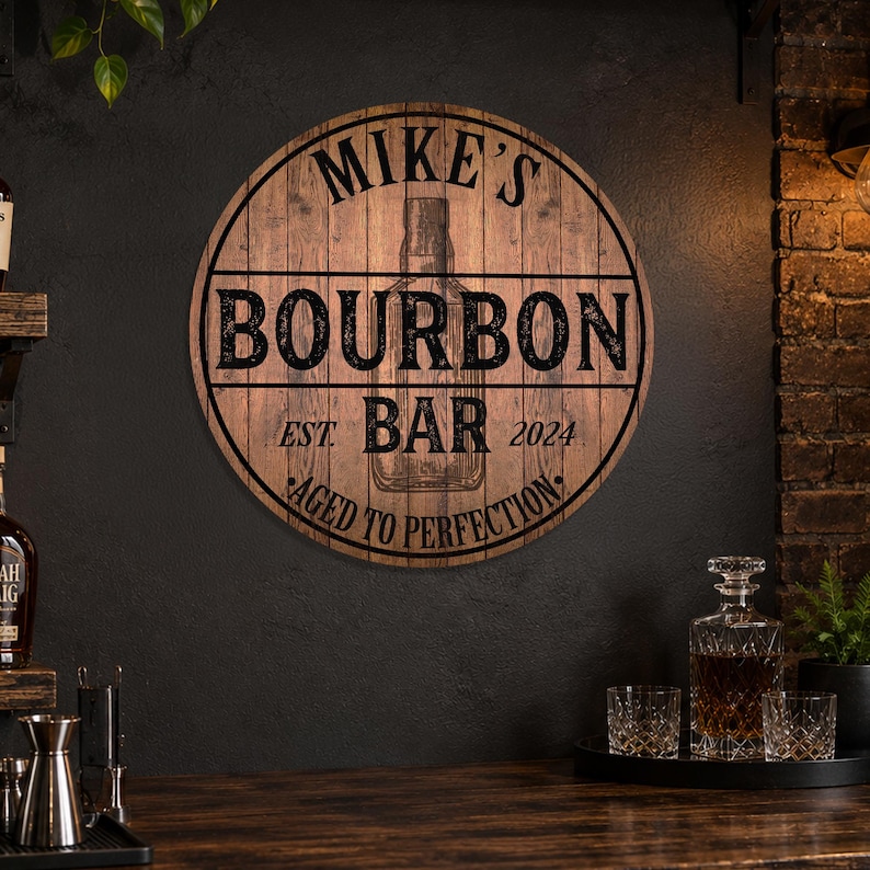 May include: A round wooden sign with the text "MIKE'S BOURBON BAR EST 2024 AGED TO PERFECTION". The sign has a dark brown background with black lettering and a graphic of a bourbon bottle.