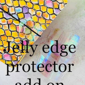 May include: A set of iridescent clear plastic edge protectors for a planner or notebook. The text "Jelly edge protector add on" is printed on a white background.