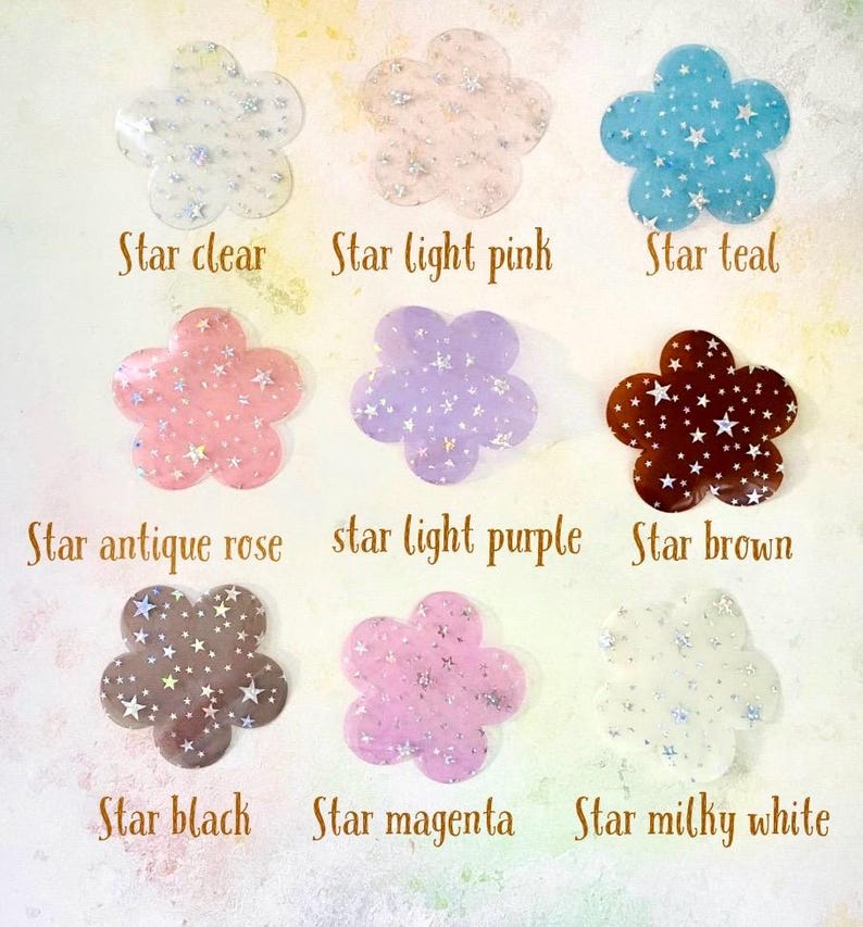 May include: Nine different colors of star-shaped flower embellishments. The colors are clear, light pink, teal, antique rose, light purple, brown, black, magenta, and milky white.
